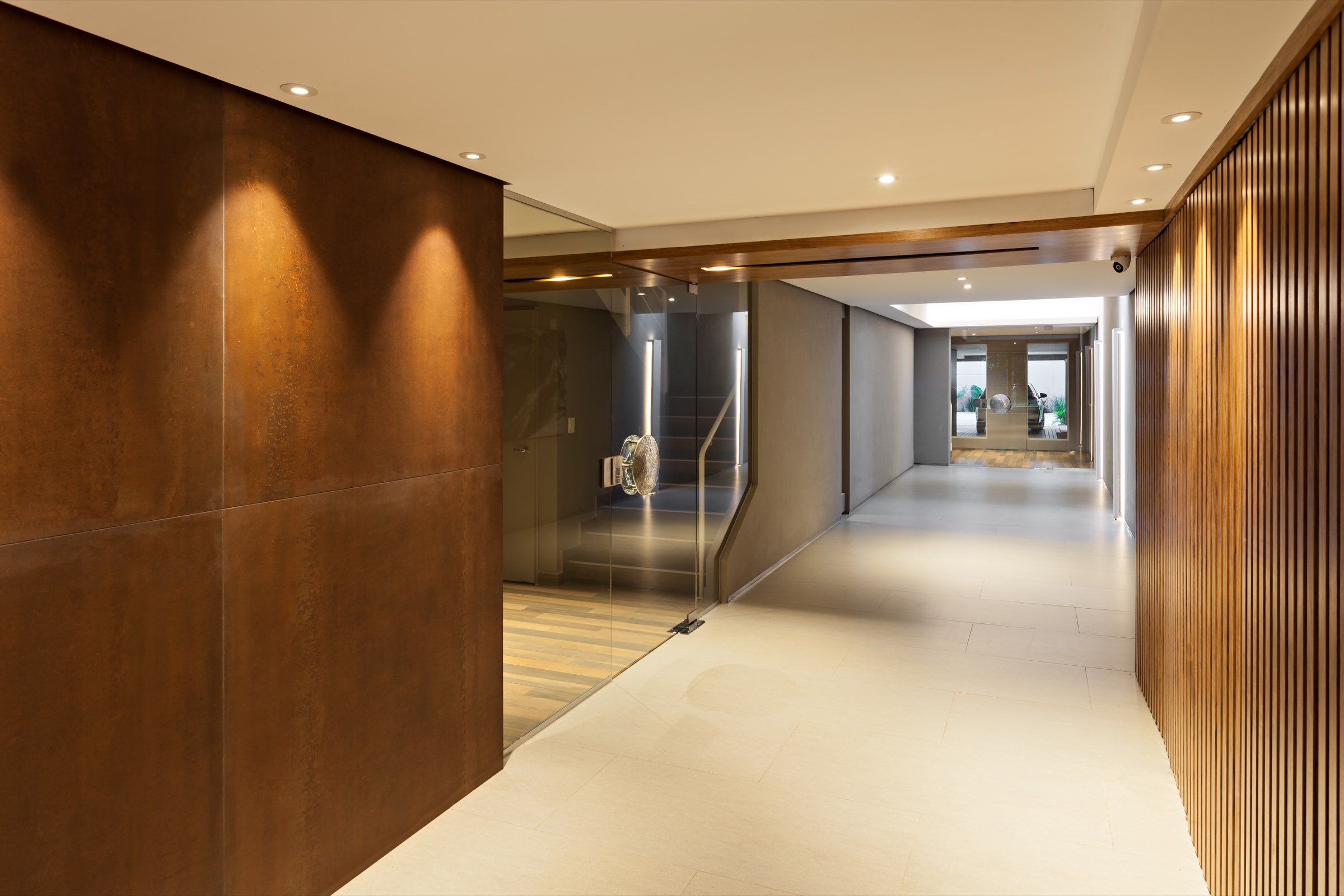 Hall de acceso de un edificio Nodeland, con muro de acero corten y listones de madera